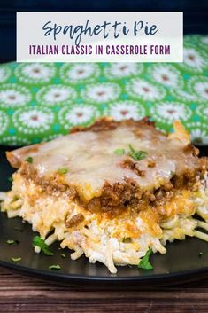 a black plate topped with lasagna casserole next to a green cloth