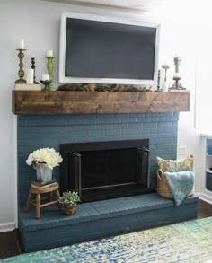 a living room with a fireplace and television on top of the mantel above it