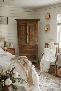 a bedroom with white walls and wooden furniture