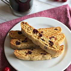 three pieces of biscuit on a white plate with a pink towel next to it