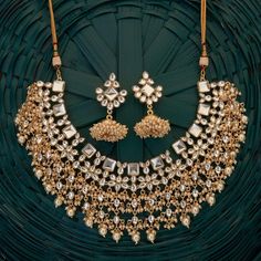 Indulge in the timeless allure of South Asian elegance with our Laasya Kundan Necklace Set. Crafted with exquisite precision, this set exudes opulence with high-quality Kundan stones and lustrous pearls. The necklace boasts intricate detailing, while the accompanying jhumka earrings showcase traditional charm with their Kundan and pearl embellishments. Elevate your ensemble with this stunning ensemble, perfect for special occasions and celebrations. Embrace the essence of Indian jewelry traditio Gold Bridal Accessories For Reception And Festivals, Gold Kundan Bridal Accessories For Celebration, Gold Bridal Sets With Cutdana For Reception, Kundan Necklace With Intricate Design For Festivals And Receptions, Kundan Necklace With Intricate Design For Reception And Festivals, Gold Bridal Necklace With Pallu For Reception, Gold Kundan Necklace With Cutdana For Reception, Gold Necklaces With Zari Work For Reception, Silver Bridal Necklace With Zari Work For Wedding