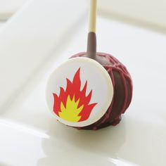 a chocolate candy with a red and yellow flame on it's center is sitting on a white surface