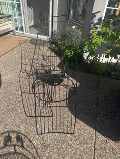 three metal planters sitting on top of a sidewalk next to a building with windows