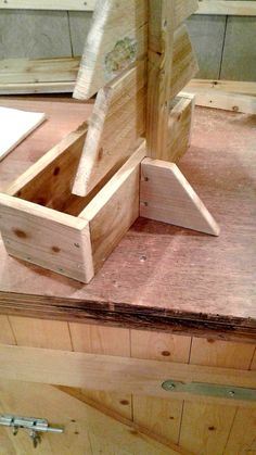 a wooden box sitting on top of a table next to a piece of plywood