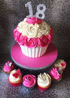 a pink and white cupcake decorated with roses