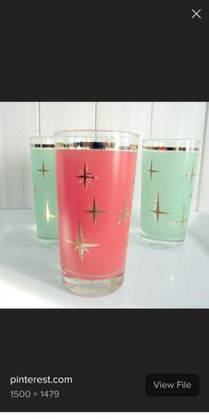 three glasses with different colors on them sitting on a white counter top next to each other