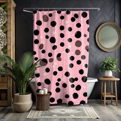 a pink and black polka dot shower curtain in a bathroom with potted plants on the floor