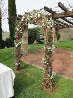 an outdoor wedding arch with flowers and vines