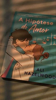 a book with an image of two people kissing each other in front of a window