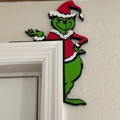 the grinch is hanging on the wall