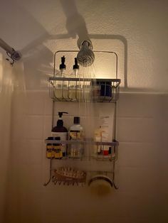 a bathroom with a shower head and soap dispenser on the wall above it