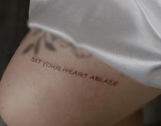 a woman's leg with the words set your heart ablaze written on it