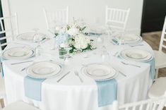 the table is set with white and blue linens