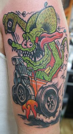 a man with a tattoo on his arm has an image of a monster driving a tractor