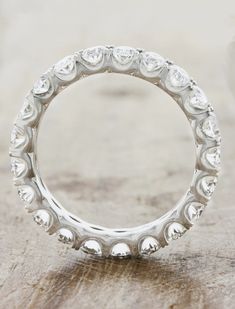 a white gold wedding ring with hearts on the side and diamonds set in the middle