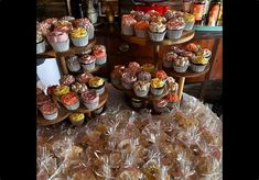 a table topped with lots of cupcakes and muffins