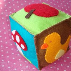 a close up of a small toy on a pink table with polka dotes and dots