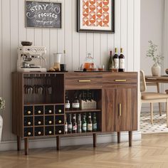 a wooden cabinet with wine glasses and bottles on it in front of a dining room table