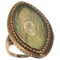 Circa 1850 14 - 15k Yellow Gold Mourning Memorial ring, in a Navette shape measuring 1 1/8 inch in length X 5/8 inch wide, light color woven hair with a center plaque with the letter "R" Hand Chasing work throughout, finger size 6 1/2. Incredible, Excellent condition considering the age. The Letter R, Memorial Ring, Regency Era, Letter R, Memorial Jewelry, Gold Hair, Memento Mori, Fashion Rings, Light Colors