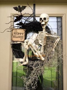 a skeleton sitting in front of a halloween wreath