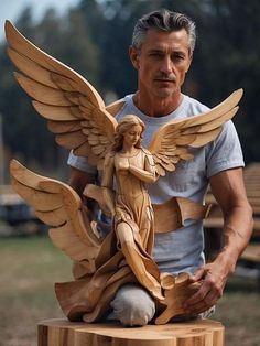 a man sitting on top of a wooden table next to a statue of an angel