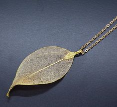 "This beautiful necklace is made with a real leaf electroformed in gold. The amazing delicate details of the leaf has been preserved by an electroforming process creating a beautiful and unique gift of nature. This necklace is durable, lightweight and very elegant. These real leaves are from the evergreen Rudraksha tree. Each leaf is unique, therefore, please expect a small variation from the leaves on the photographs. The leaves are around 2 inches (5cm) long, delicate looking but strong. Neckl Woodland Jewelry, Real Leaf, Mermaid Jewelry, Real Leaves, Natural Jewelry, Gothic Necklace, Authentic Jewelry, Leaf Jewelry, Silver Jewelry Handmade