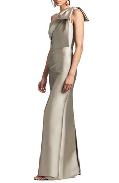 a woman wearing a long silver dress with one shoulder and an open slit on the side