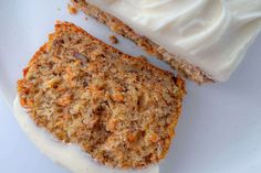 two slices of carrot cake on a plate with cream cheese frosting next to it