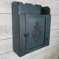 an old wooden wall mounted mailbox on a white painted wood wall with ornate carvings