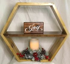 a wooden shelf that has a candle and some decorations on it with the word joy