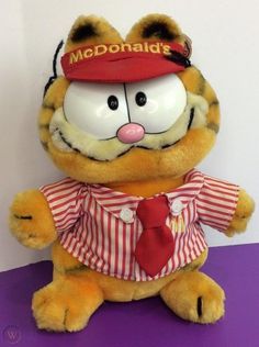 a stuffed animal wearing a red hat and striped shirt