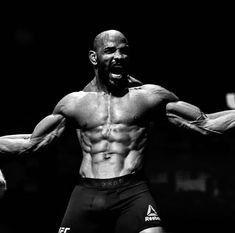 a black and white photo of a man flexing his muscles in front of the camera