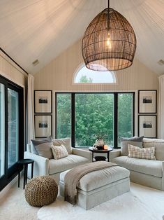 a living room with two couches and a coffee table in front of large windows