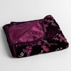 a purple and black blanket laying on top of a white table