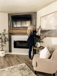 a woman standing next to a fireplace in a living room