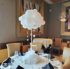 a dining room table set for a party with balloons and place settings on the table