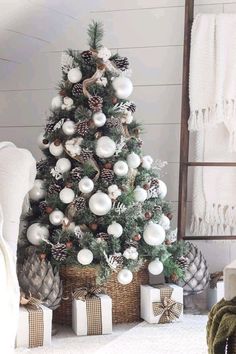 a christmas tree with white balls and pine cones on it in front of a window