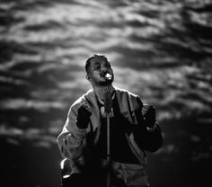 a man singing into a microphone on stage