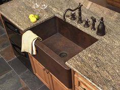 a kitchen sink sitting under a faucet next to a counter top with a towel on it