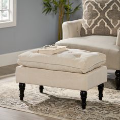 a white ottoman sitting on top of a rug