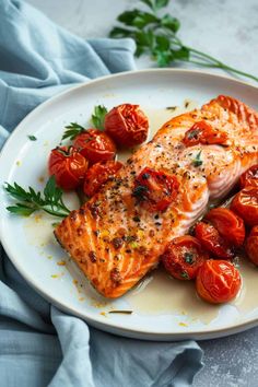 salmon and cherry tomatoes on a white plate