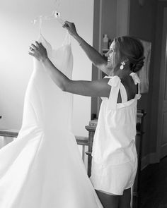 a woman is trying on her wedding dress