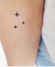 a woman's arm with three small stars on the back of her left arm