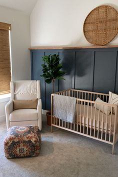 a baby's room with a crib, chair and ottoman