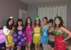 a group of young women standing next to each other in front of a bed with balloons