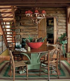 a dining room table with chairs and a red bowl on top of it in front of a spiral staircase