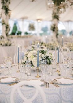 the table is set with white flowers and blue candles for an elegant wedding breakfasteon