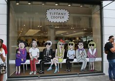 a group of people standing in front of a store window with cartoon characters on it