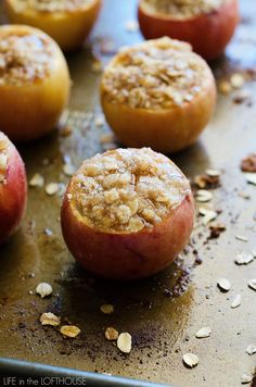 baked apples with oatmeal toppings on a baking sheet, ready to be eaten