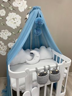 a baby crib with blue canopy and white bedding